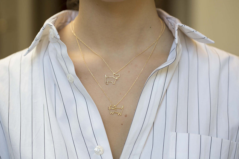 Gold chain necklace with dog shaped pendant and small diamond worn by model