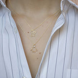 Gold chain necklace with family shaped pendant worn by model