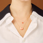 Gold chain necklace with sun shaped coral pendant worn by model