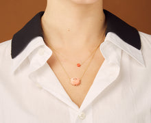 Load image into Gallery viewer, Gold chain necklace with sun shaped coral pendant worn by model
