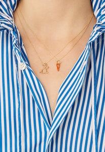 Model wearing gold chain necklaces with carrot and rabbit shaped pendants