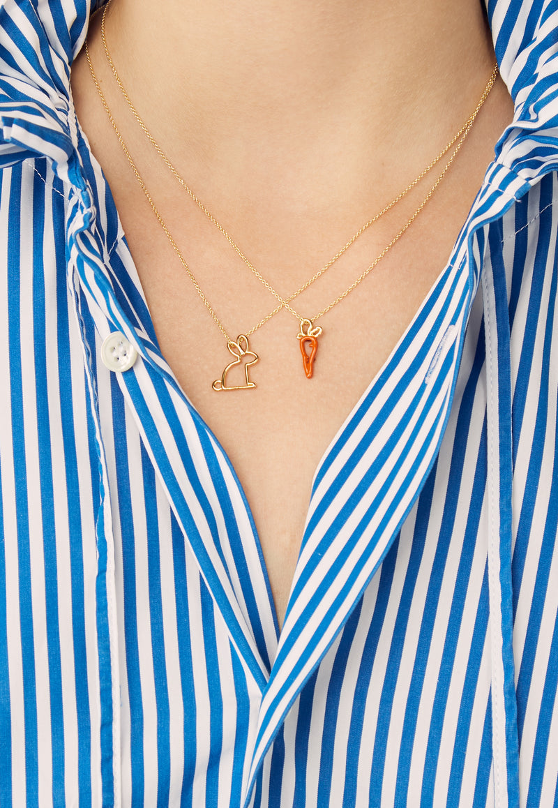 Model wearing gold chain necklaces with carrot and rabbit shaped pendants