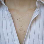 Gold chain necklace with space shuttle shaped pendant with pearl worn by model