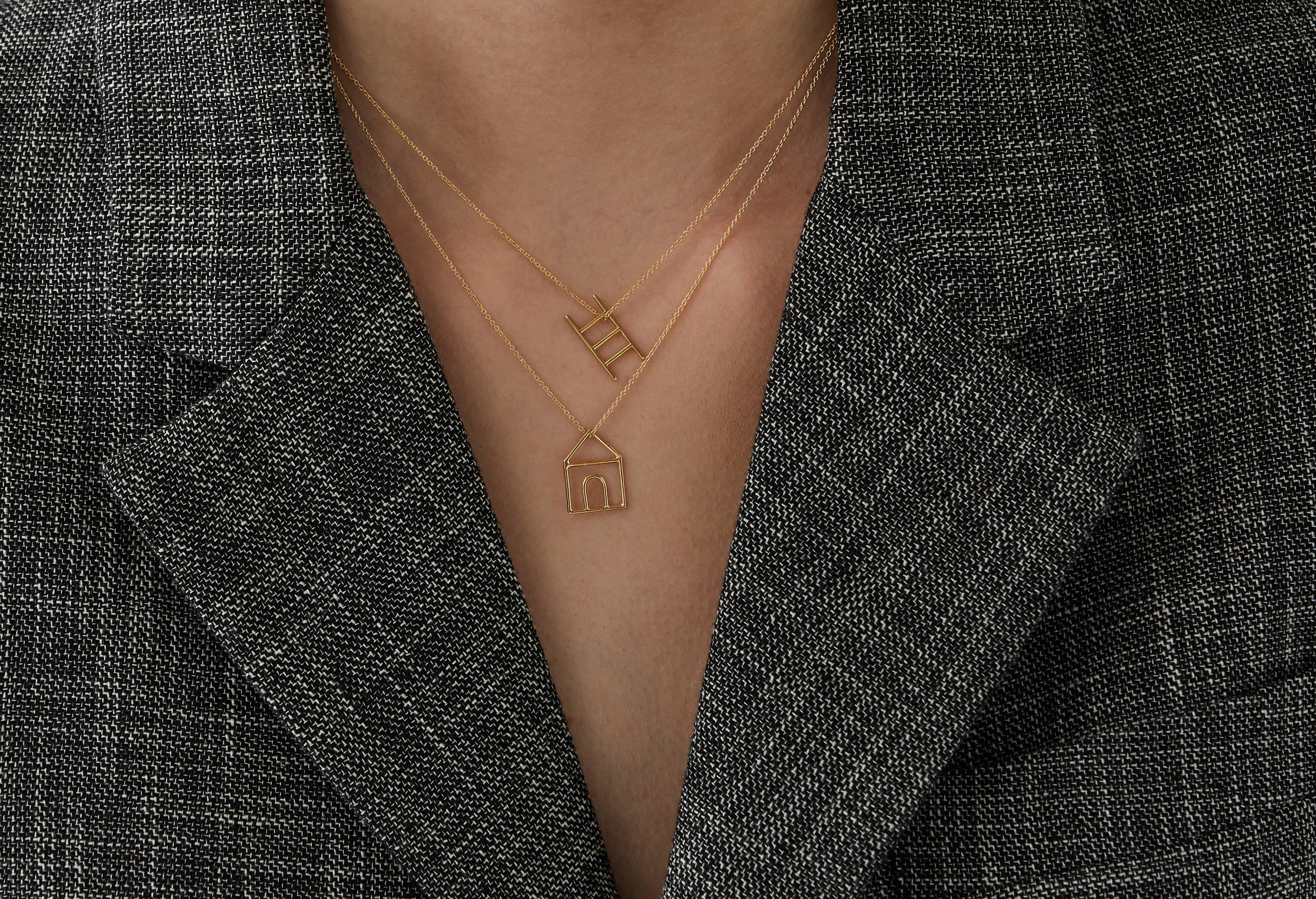 Gold chain necklace with stairs shaped pendant worn by woman