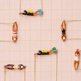 Jewelry composition with gold necklaces with swimmer and scuba divers shaped pendants