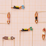 Jewelry composition with gold necklaces with swimmer shaped pendants