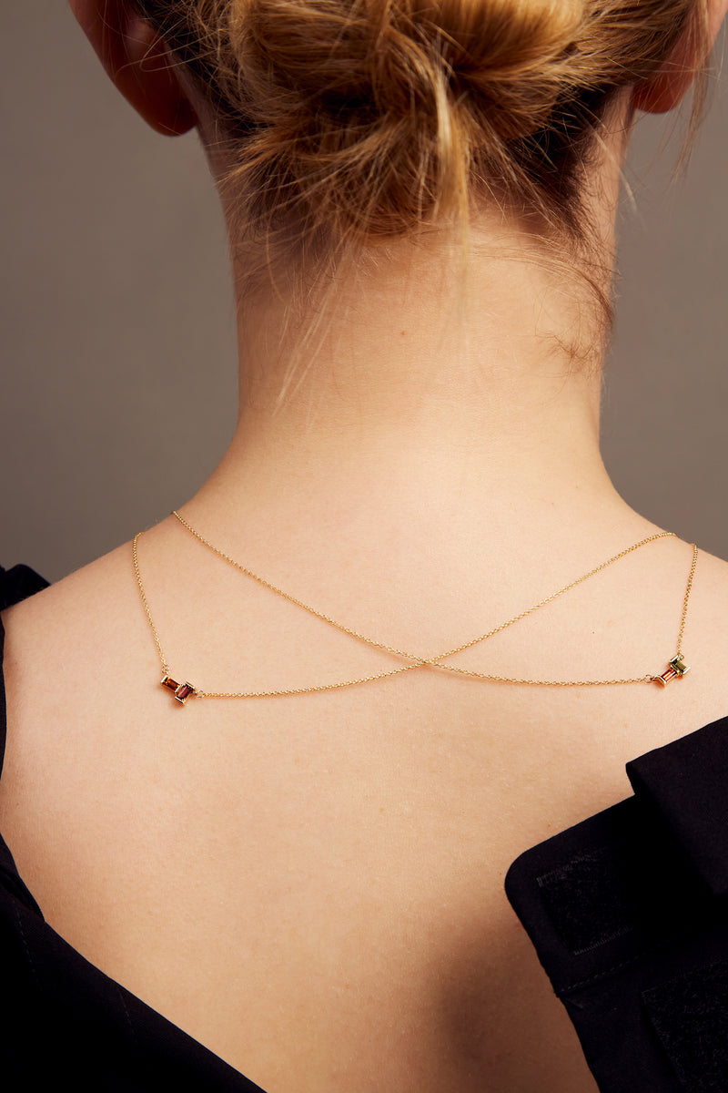 Gold rolo chain necklaces with a baguett cut stones on woman
