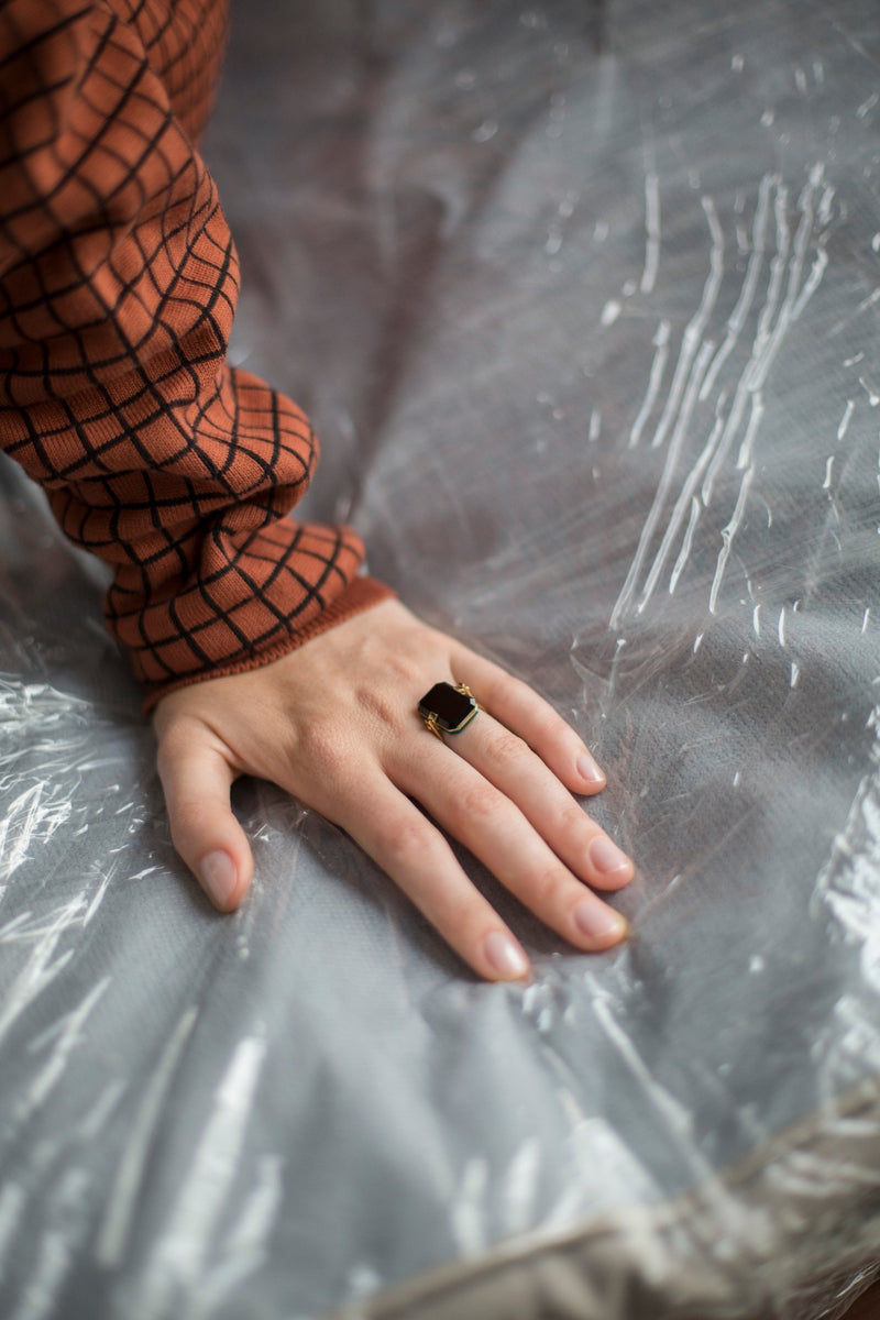 Gold ring with black agate and malachite stones worn by model