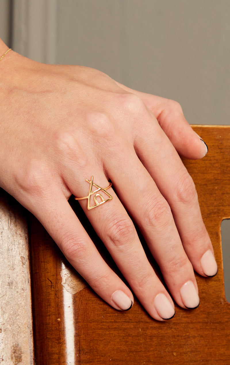 Gold tepee shaped ring on model's hand
