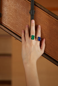 Gold ring with malachite and black agate stones worn by model's hand