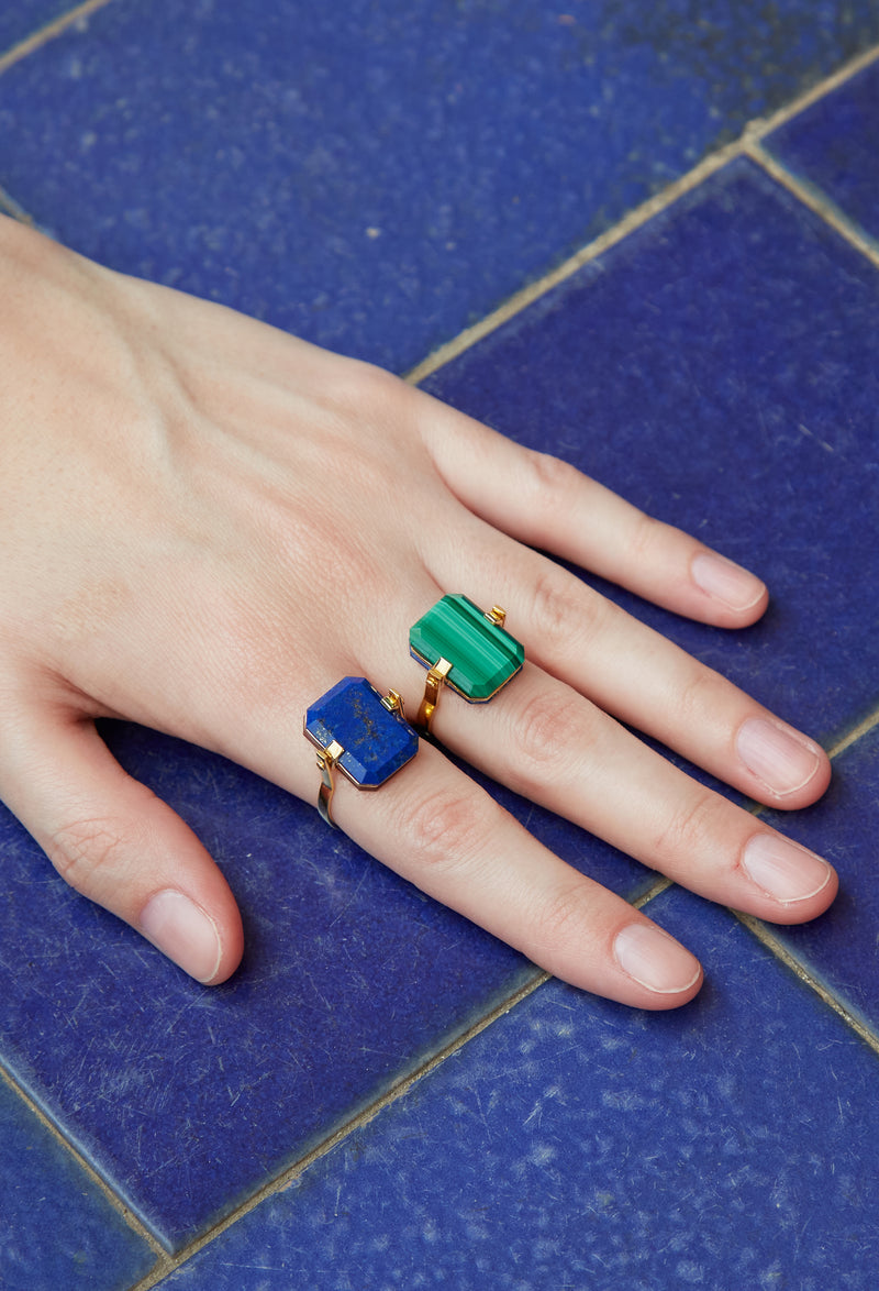 Model wearing gold turning rings with lapis and malachite