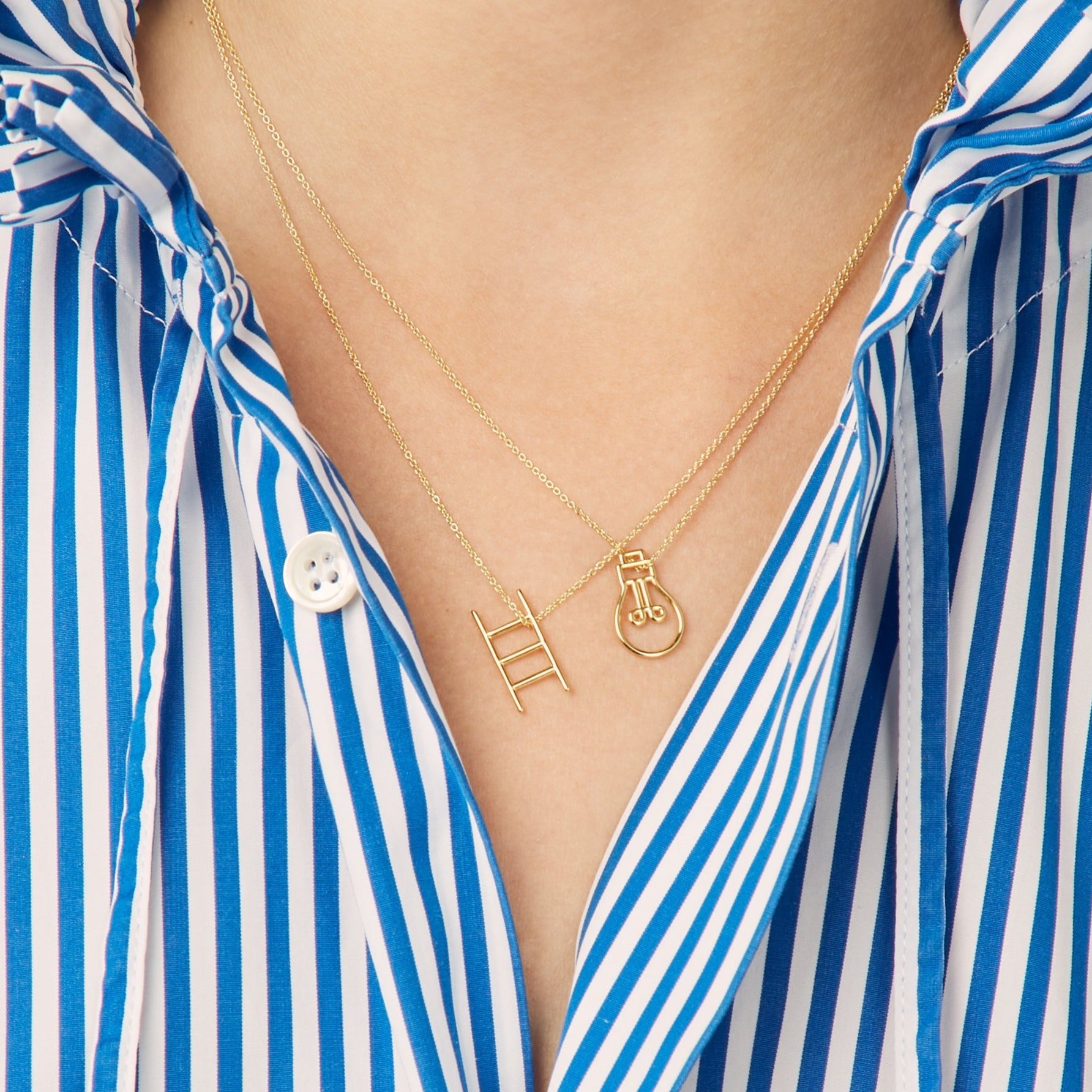 Gold chain necklace with stairs shaped pendant worn by model