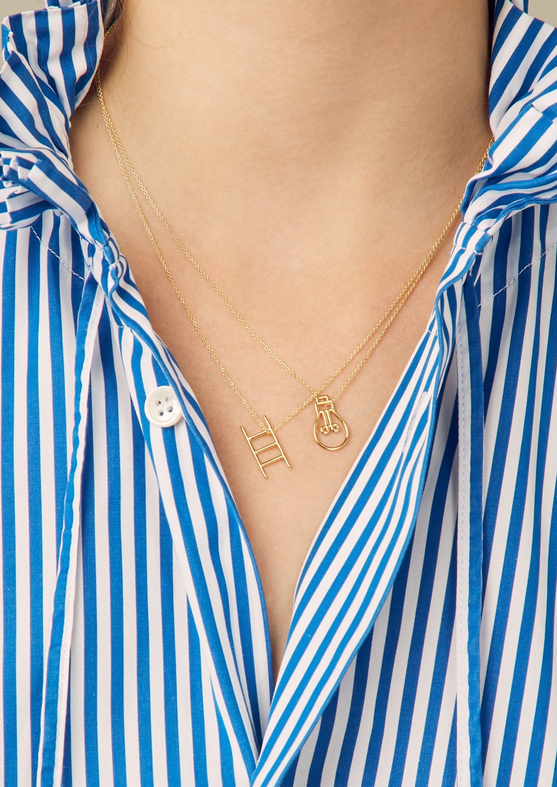 Gold chain necklace with stairs shaped pendant worn by model