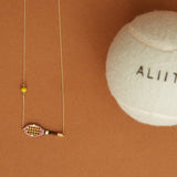 Gold chain necklace with gold tennis racquet and ball shaped pendants in pink and yellow enamel detail