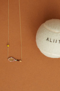 Gold chain necklace with gold tennis racquet and ball shaped pendants in pink and yellow enamel detail