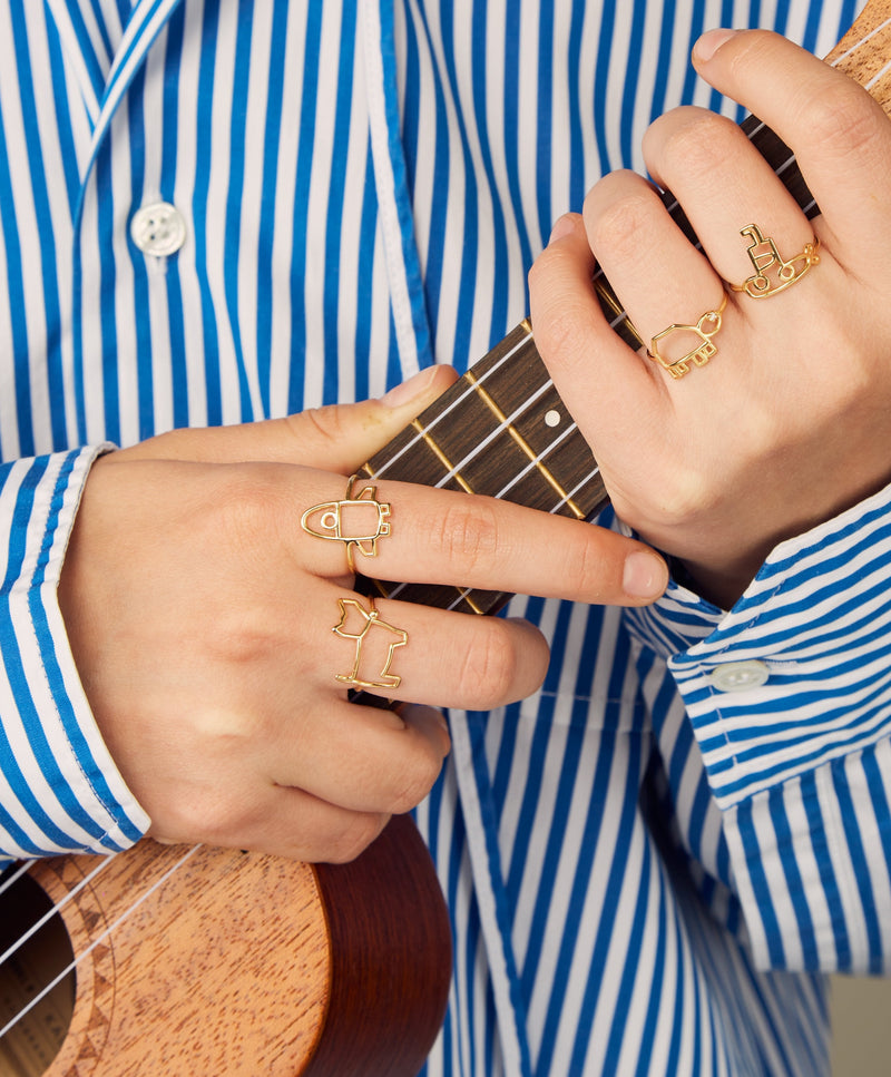 Model playing ukulele wearing gold rings