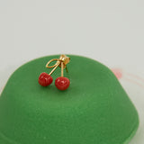 Green sweet pastry with coral cherries gold earring on top